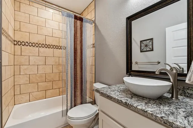 a bathroom with a granite countertop sink toilet mirror and shower