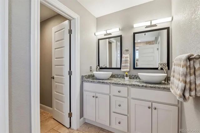 a bathroom with a granite countertop sink and a mirror