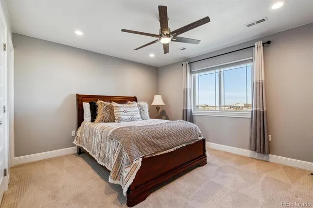 a bedroom with a bed and a ceiling fan