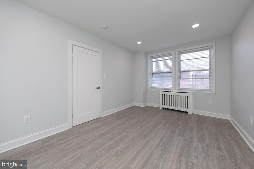 4247 Locust Street, Unit 0B115 Philadelphia, PA 19104 - Photo 30 of 38 a view of an empty room with wooden floor and a window