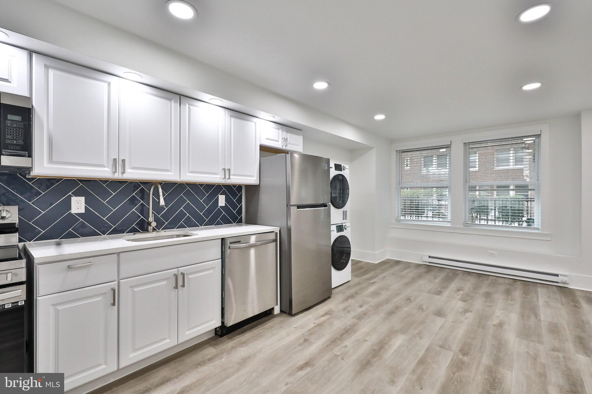 4247 Locust Street, Unit 0B115 Philadelphia, PA 19104 - Photo 6 of 38 a kitchen with stainless steel appliances granite countertop a refrigerator sink and cabinets
