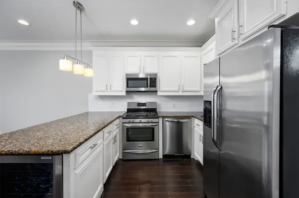 a kitchen with kitchen island granite countertop a sink stove and refrigerator