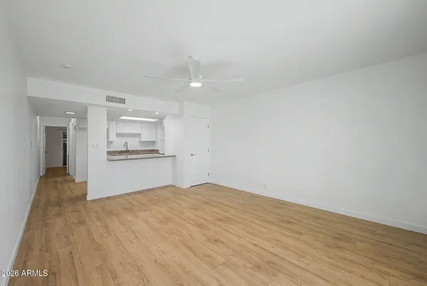 a view of empty room with kitchen and sink