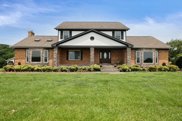 a front view of a house with a yard and potted plants