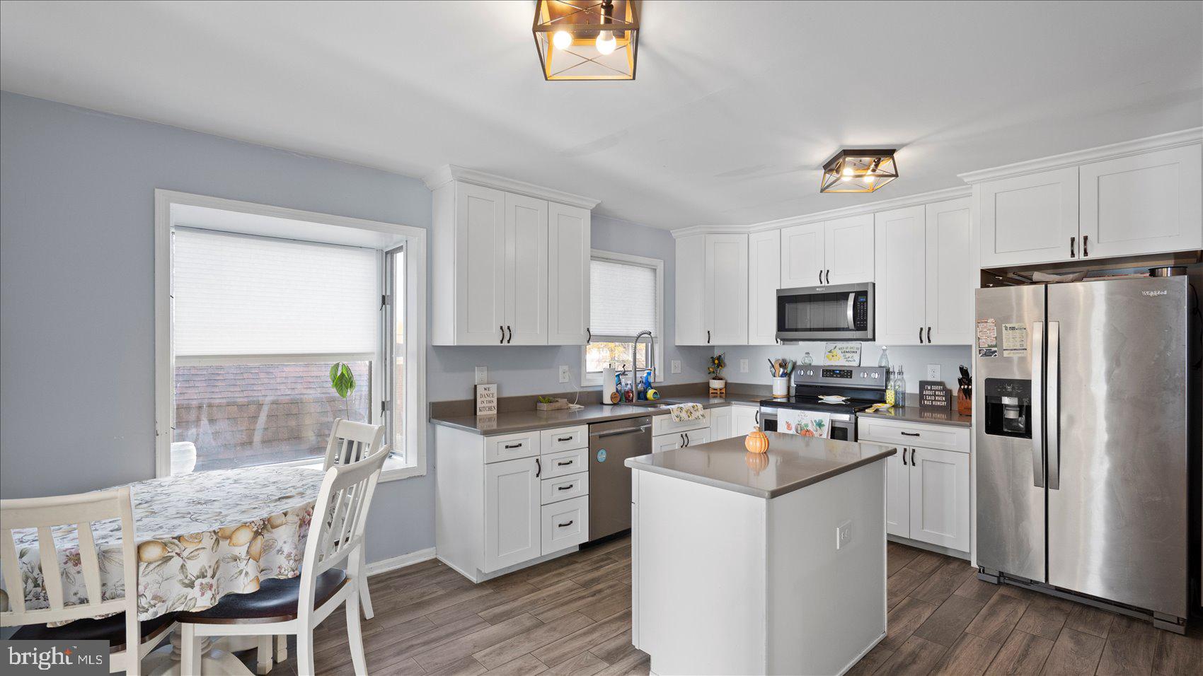 9905 Magledt Road Baltimore, MD 21234 - Photo 11 of 45 a kitchen with a stove a sink dishwasher a refrigerator with a dining table and chairs