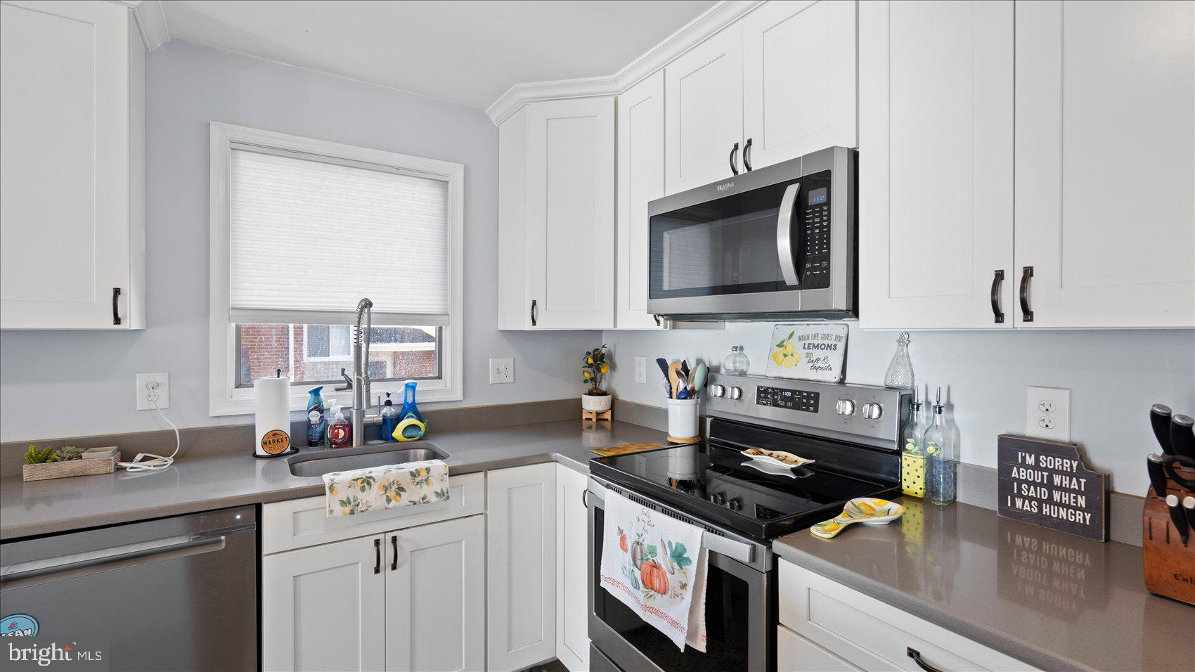 9905 Magledt Road Baltimore, MD 21234 - Photo 14 of 45 a kitchen with stainless steel appliances granite countertop a stove a sink and a microwave