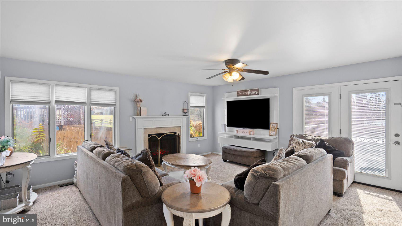 9905 Magledt Road Baltimore, MD 21234 - Photo 5 of 45 a living room with furniture a flat screen tv and a fireplace