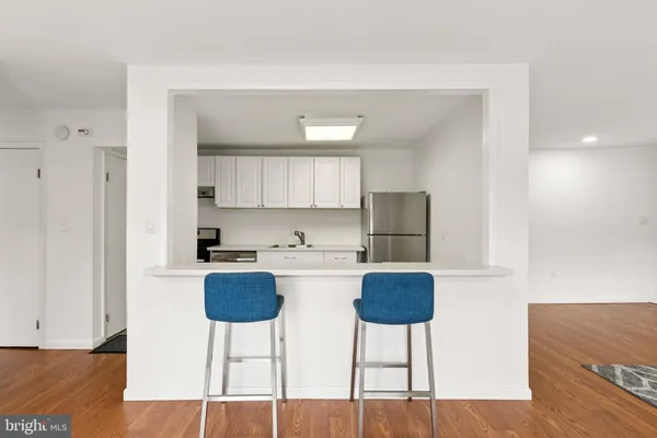 a kitchen with kitchen island a stove a table and chairs