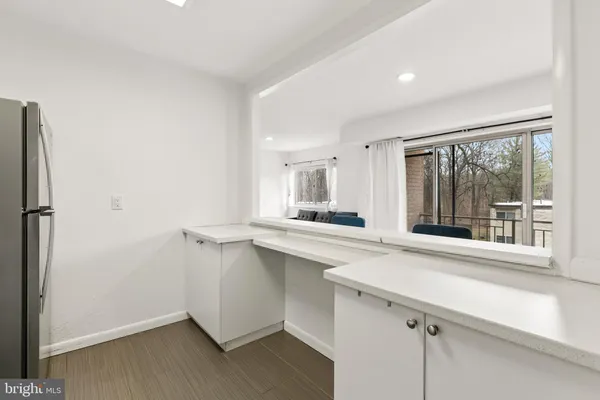 a kitchen with a sink cabinets stainless steel appliances and a large window