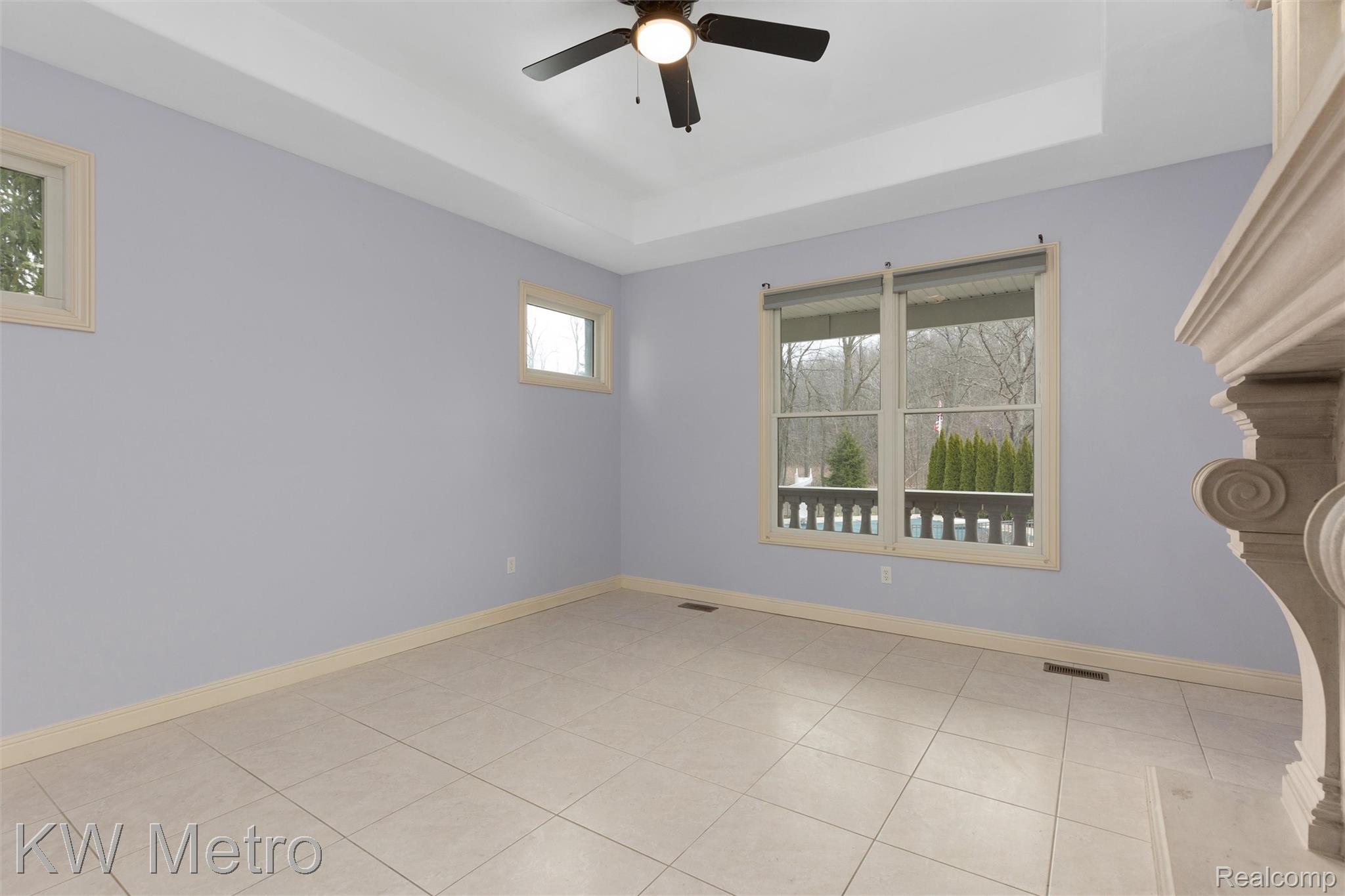 65884 Windrose Court Ray, MI 48096 - Photo 47 of 82 1st floor bedroom with a tray ceiling, a ceiling fan, and light tile patterned flooring