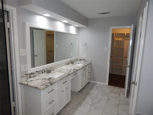 a bathroom with a granite countertop sink and a mirror