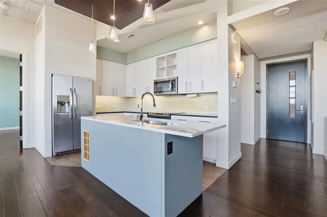 a view of kitchen with stainless steel appliances granite countertop a stove and a refrigerator