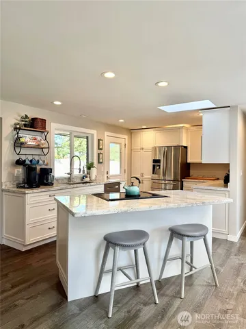 a kitchen with sink a stove and chairs