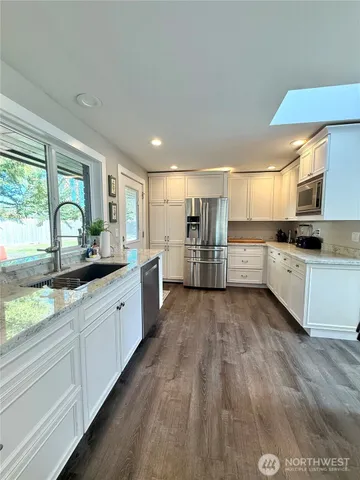 a large kitchen with cabinets and wooden floor