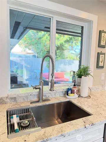 a kitchen with a sink a counter top space and a window