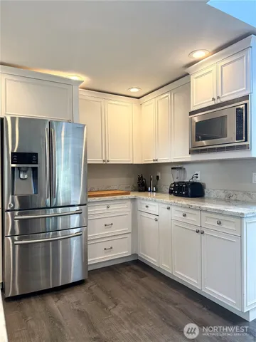 a kitchen with stainless steel appliances cabinets and a window