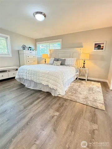 a bedroom with a large bed and wooden floor