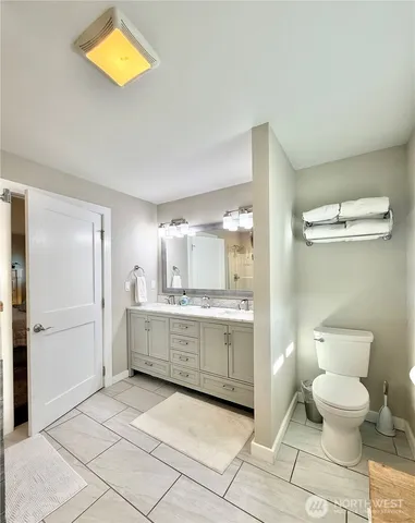 a bathroom with a granite countertop sink mirror vanity and toilet