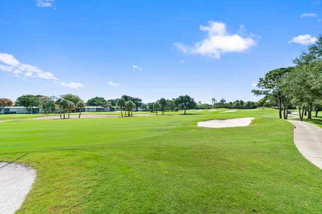 a view of a swimming pool with a patio and a yard