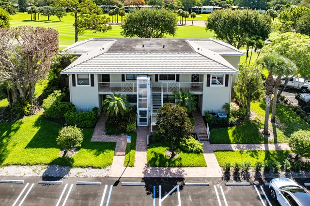 an aerial view of residential houses with outdoor space and trees