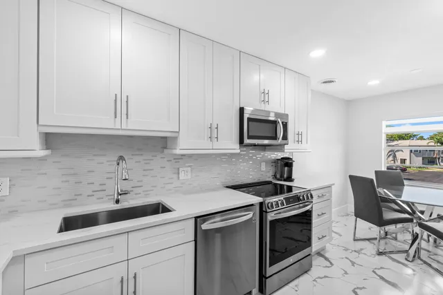 a kitchen with stainless steel appliances kitchen island granite countertop a sink and cabinets