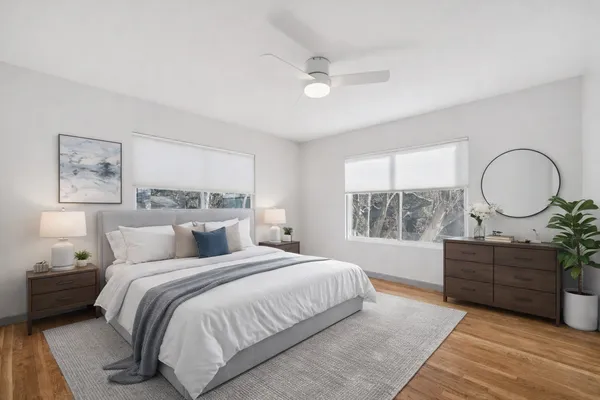 a bedroom with a bed mirror and a window