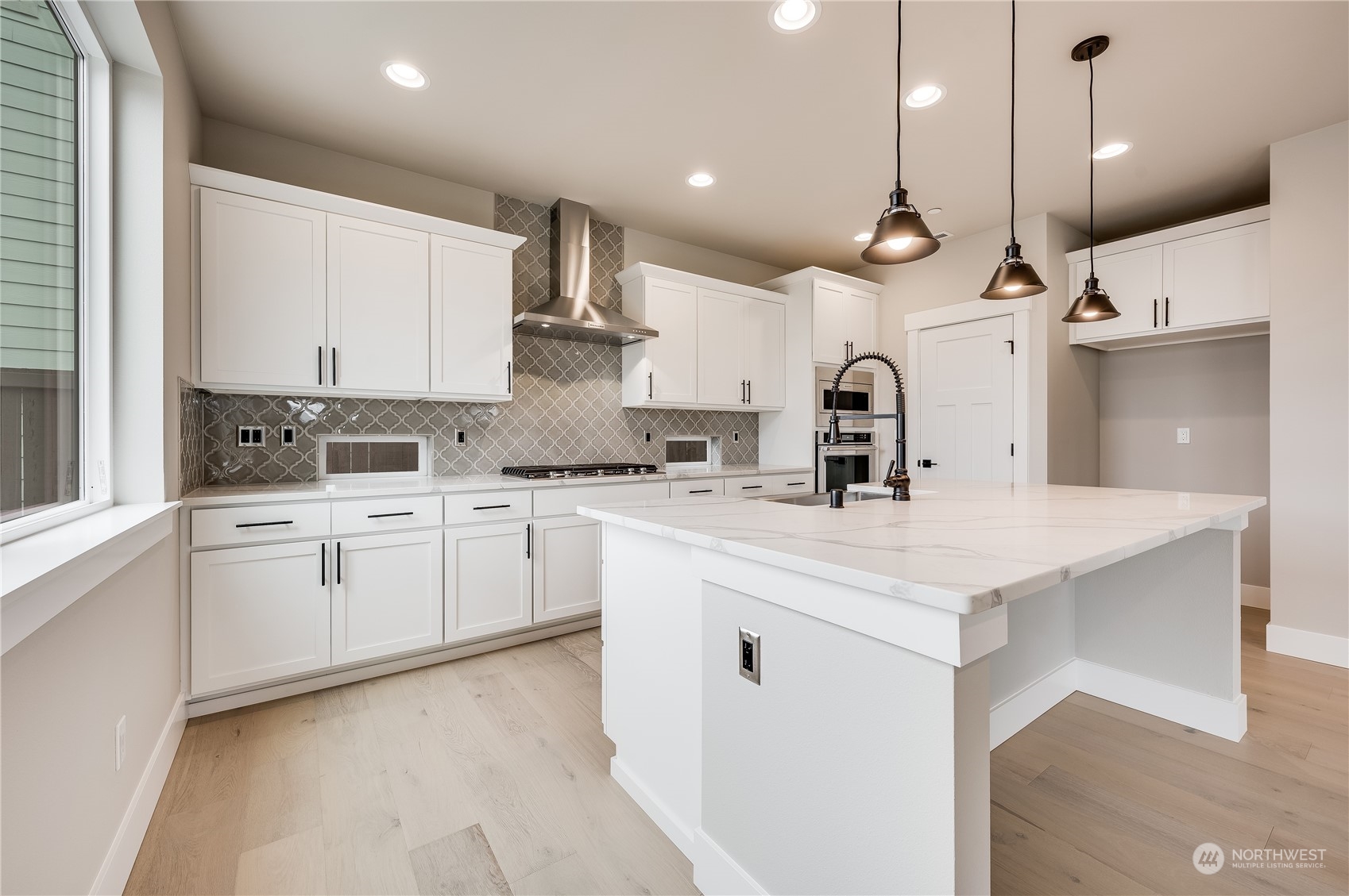 4439 244th Street Southeast Bothell, WA 98021 - Photo 12 of 29 a kitchen with a white center island a sink stainless steel appliances and cabinets