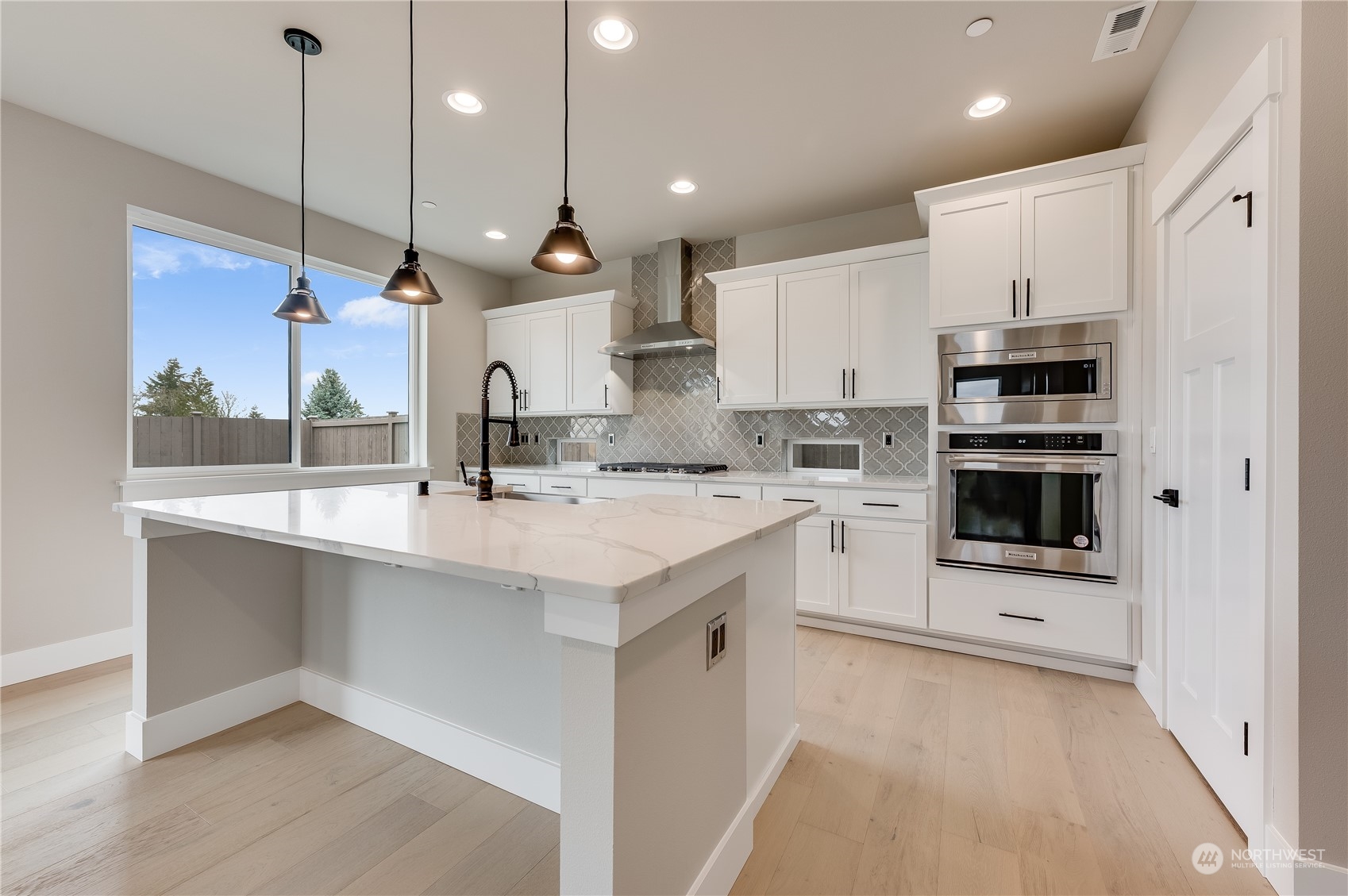 4439 244th Street Southeast Bothell, WA 98021 - Photo 13 of 29 a large kitchen with kitchen island a sink stainless steel appliances and white cabinets