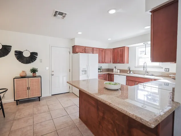 a kitchen with stainless steel appliances granite countertop a sink stove and refrigerator