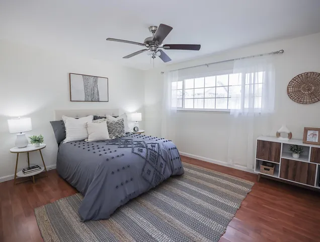 a bedroom with a bed and wooden floor
