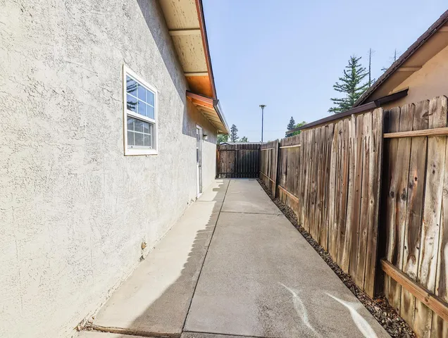 a view of a house with a yard and large tree