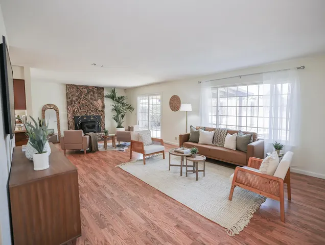 a living room with furniture wooden floor and a large window