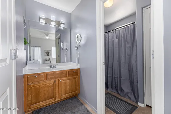a bathroom with a granite countertop sink a mirror and a shower