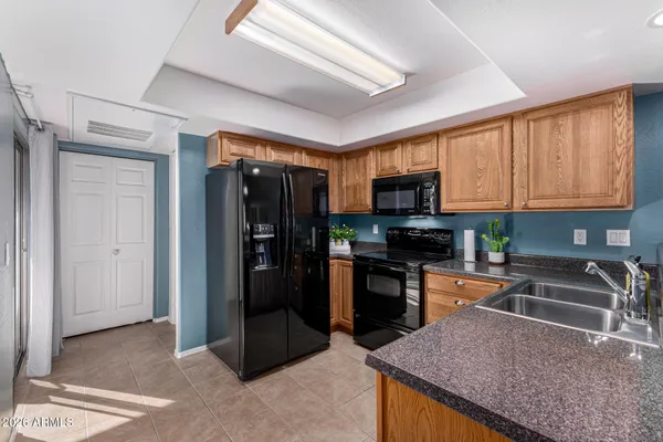 a kitchen with stainless steel appliances granite countertop a refrigerator a stove top oven a sink and dishwasher