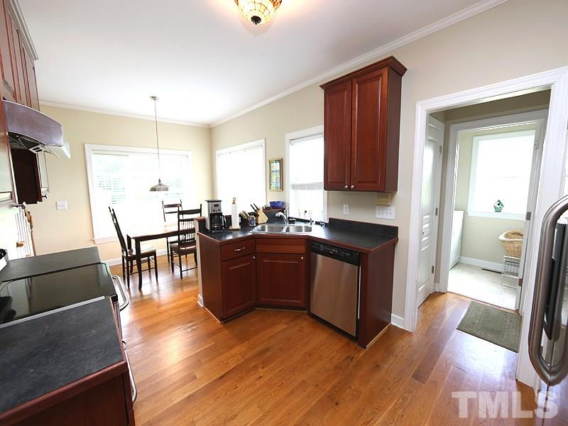130 Russell Union Road Norlina, NC 27563 - Photo 9 of 20 a kitchen with stainless steel appliances granite countertop a stove top oven a sink a dining table and chairs with wooden floor