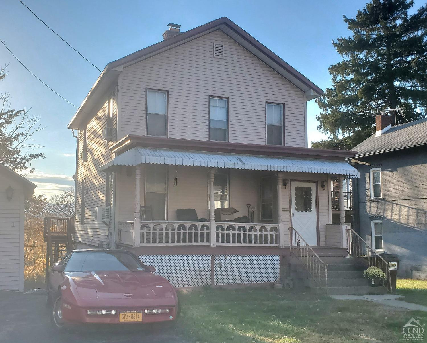 109 Summit Avenue Catskill, NY 12414 - Photo 12 of 12 a view of a white house with large windows and a small yard