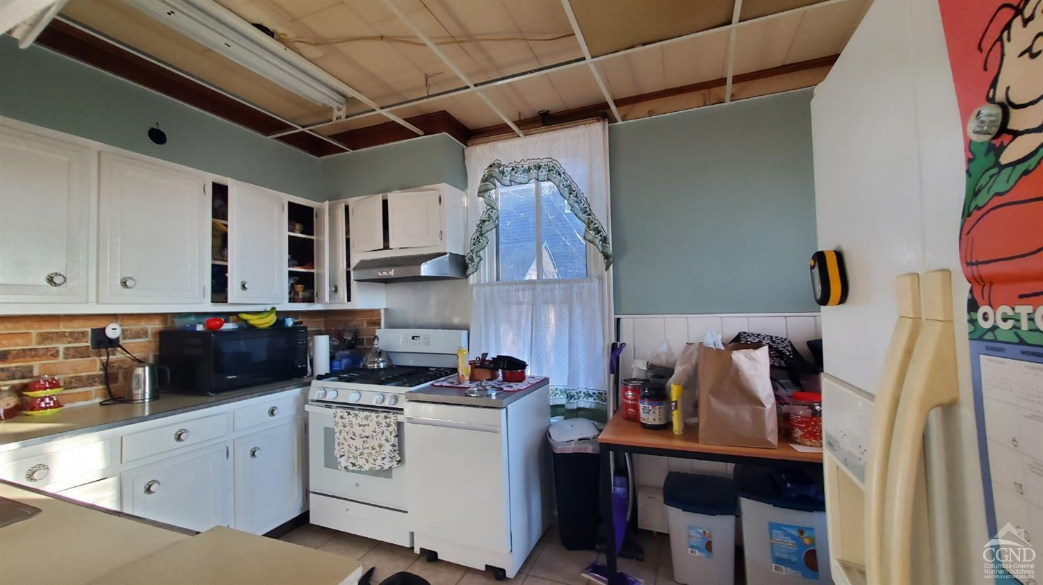 109 Summit Avenue Catskill, NY 12414 - Photo 4 of 12 a view of a kitchen with refrigerator and cabinets