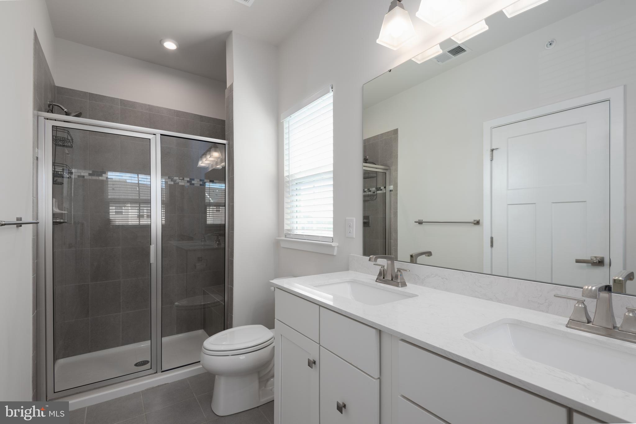627 Quarry Point Road Malvern, PA 19355 - Photo 17 of 24 a bathroom with a shower sink vanity and toilet