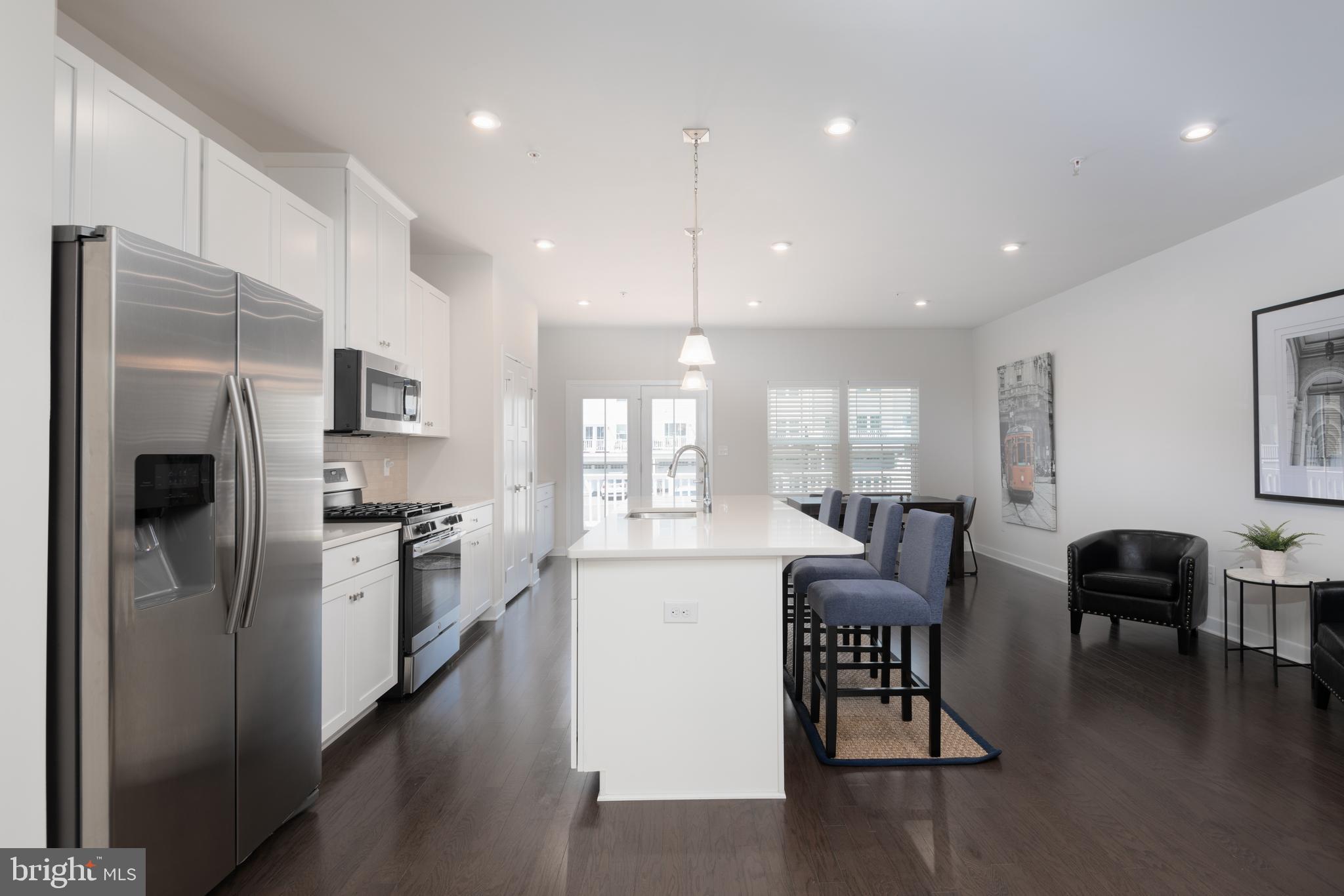 627 Quarry Point Road Malvern, PA 19355 - Photo 8 of 24 a kitchen with stainless steel appliances kitchen island granite countertop a refrigerator a stove a sink a dining table and chairs with wooden floor
