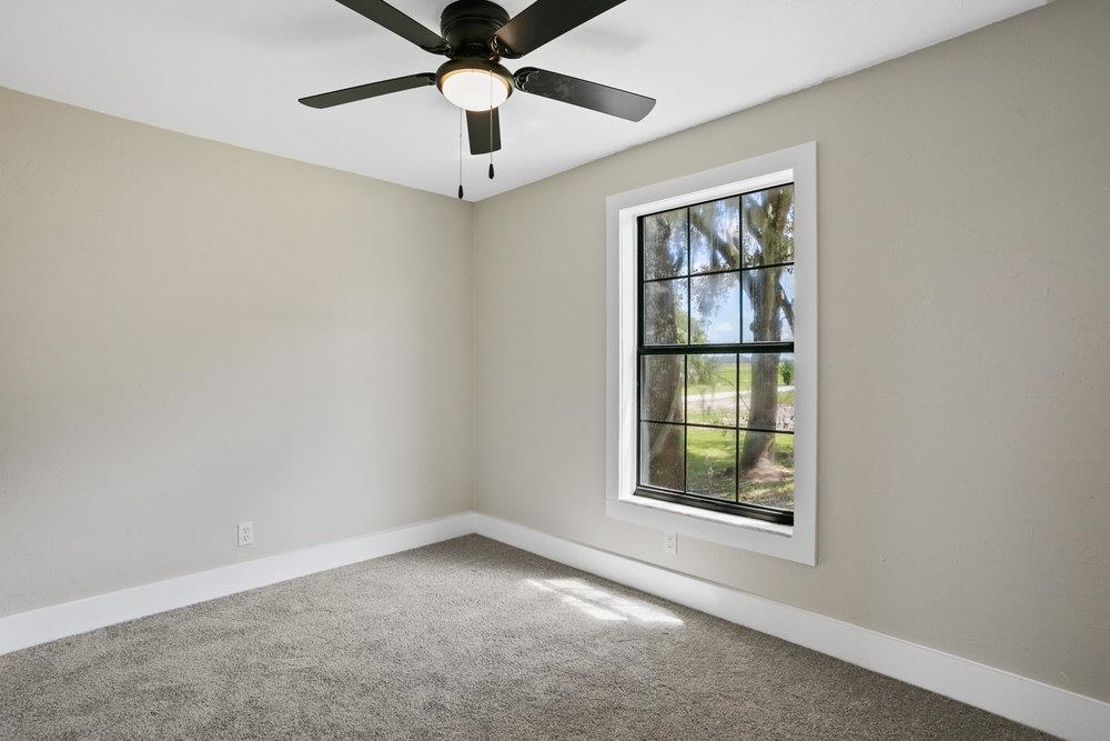 137 Mays Cove Road East Palatka, FL 32131 - Photo 22 of 70 an empty room with windows and ceiling fan
