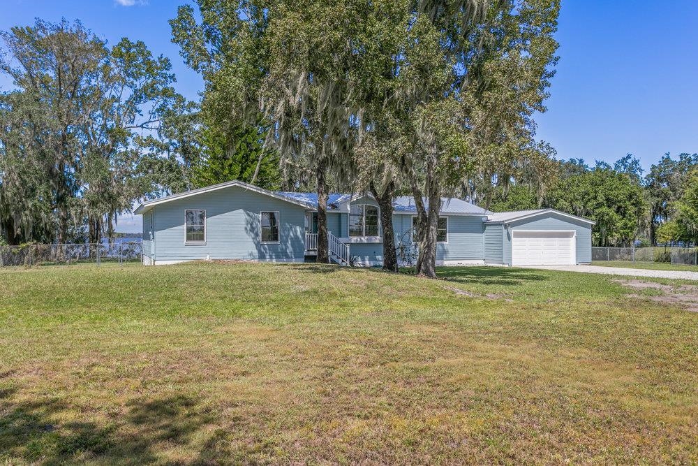 137 Mays Cove Road East Palatka, FL 32131 - Photo 3 of 70 a backyard of a house with large trees and wooden fence