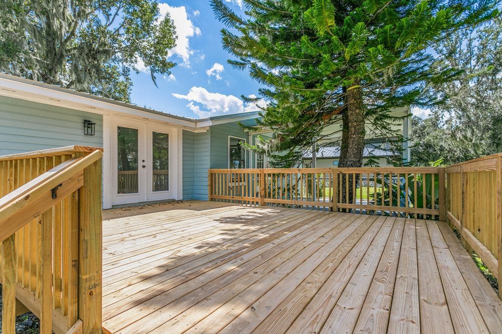 137 Mays Cove Road East Palatka, FL 32131 - Photo 43 of 70 a view of a deck with wooden floor and fence with a large tree
