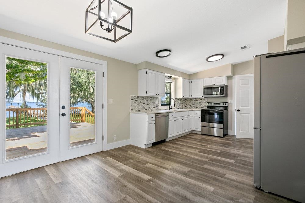 137 Mays Cove Road East Palatka, FL 32131 - Photo 8 of 70 a kitchen with stainless steel appliances a refrigerator and a stove top oven