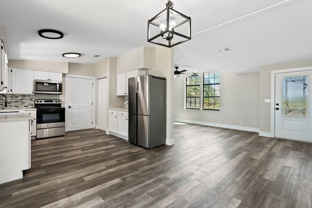 137 Mays Cove Road East Palatka, FL 32131 - Photo 9 of 70 a view of a kitchen with stainless steel appliances wooden floor and a window