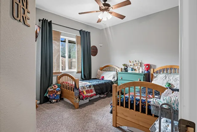 a bedroom with three beds and a window