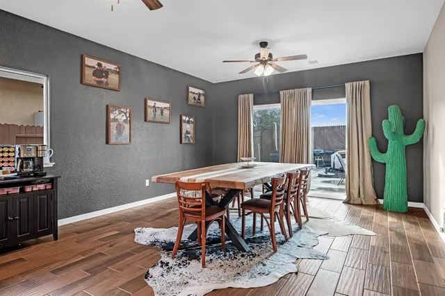 a dining room with wooden floor a chandelier a wooden table and chairs