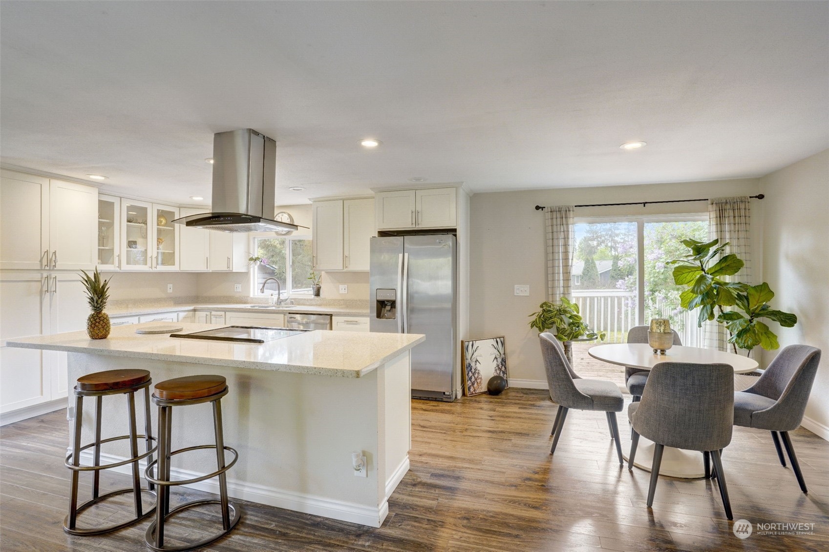 968 Brookdale Road East Tacoma, WA 98445 - Photo 9 of 31 a kitchen with kitchen island a stove a table and chairs in it