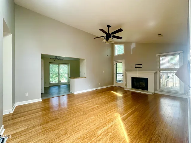 a view of empty room with wooden floor and fireplace