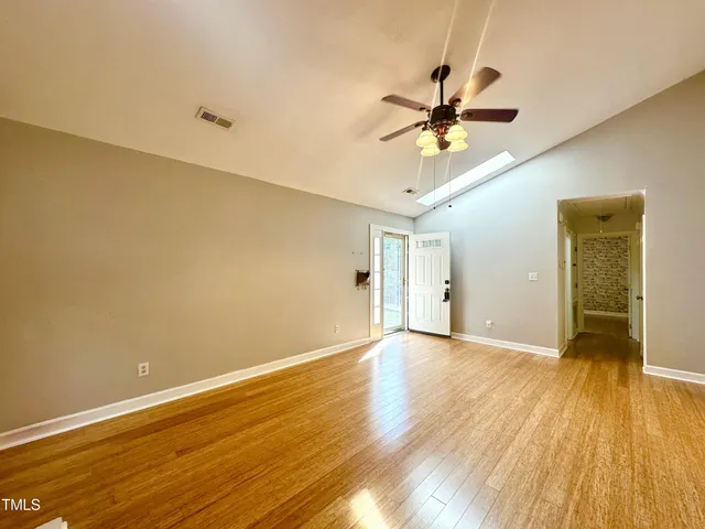 a view of a room with wooden floor and a ceiling fan