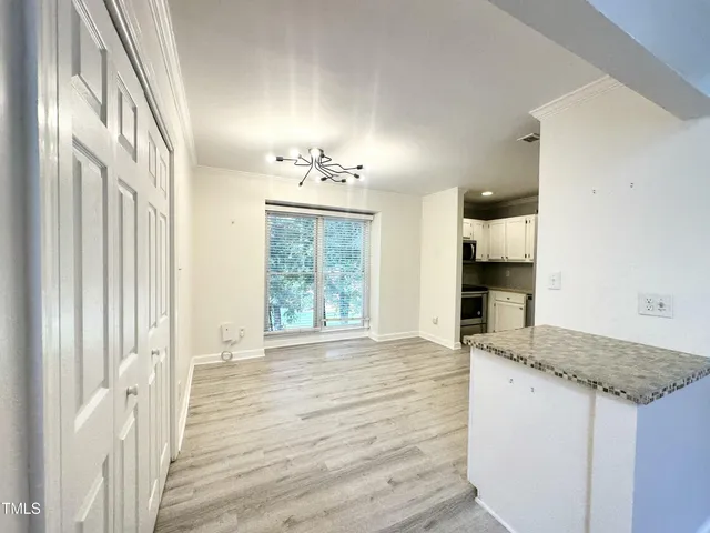 a view of kitchen and hall with wooden floor